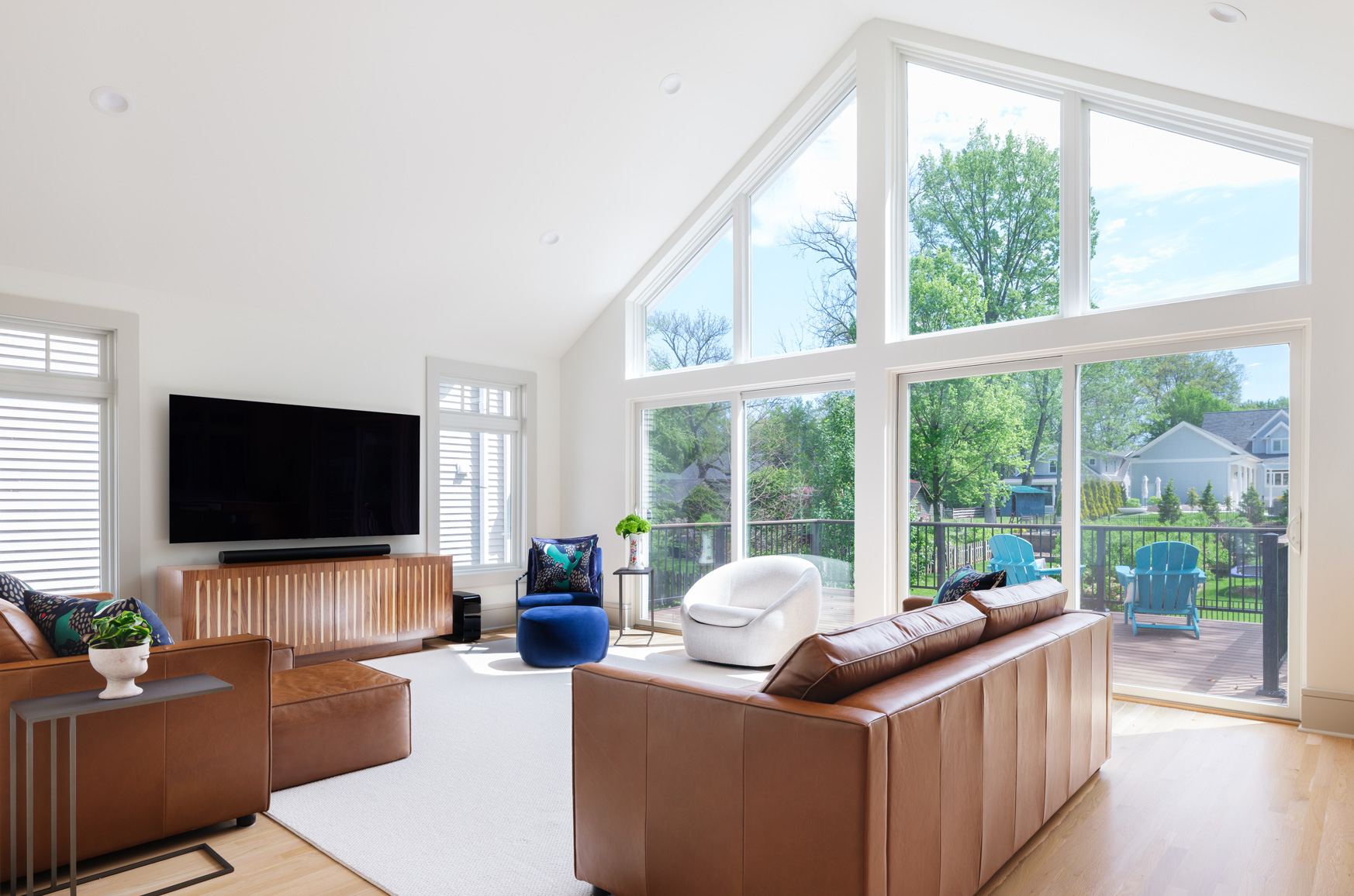 Living room with floor-to-ceiling windows and leather seating in Webster Groves, Missouri — multi-room remodel by Hercules Design Build