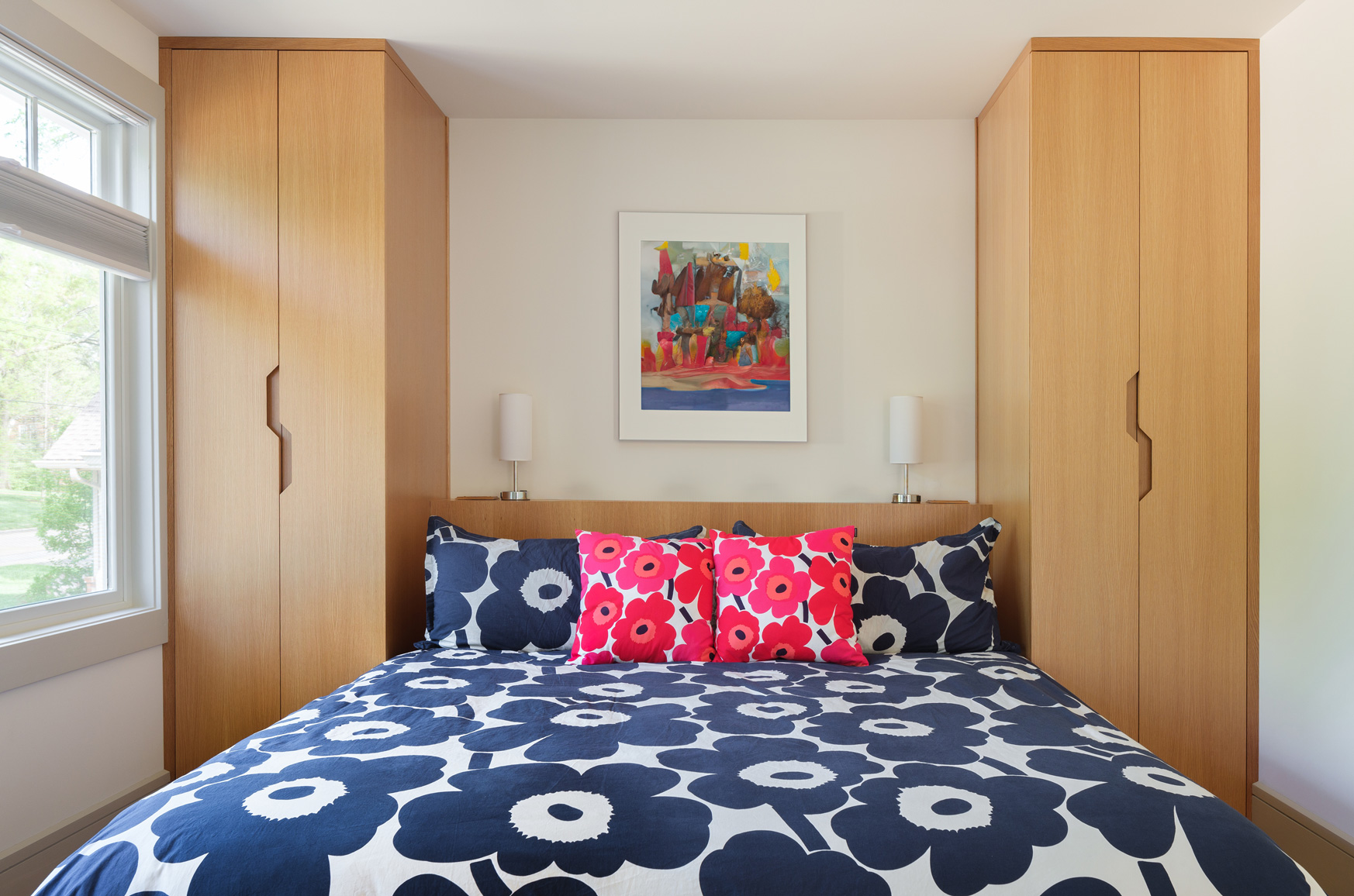 Bedroom with custom wood storage and bold floral bedding in Webster Groves, Missouri — multi-room remodel by Hercules Design Build