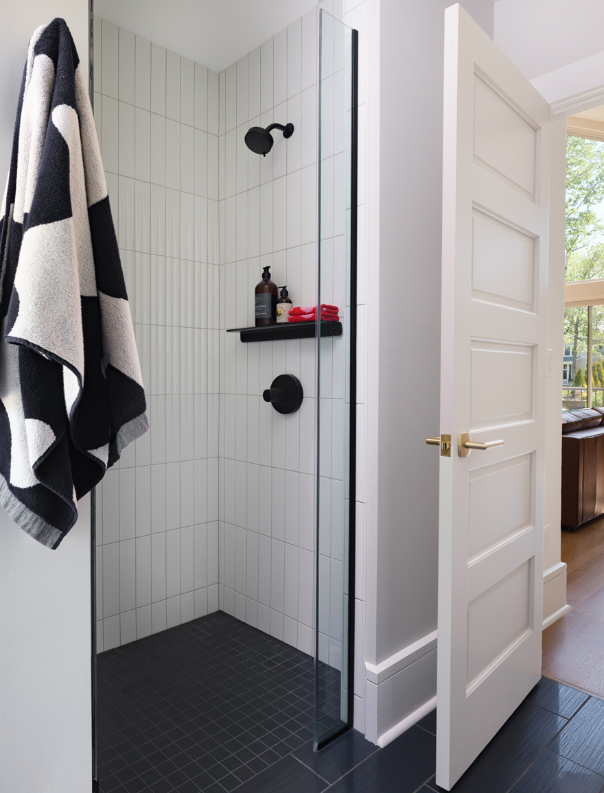 Walk-in shower with white vertical tile and matte black fixtures in Webster Groves, Missouri — architect remodeling St. Louis